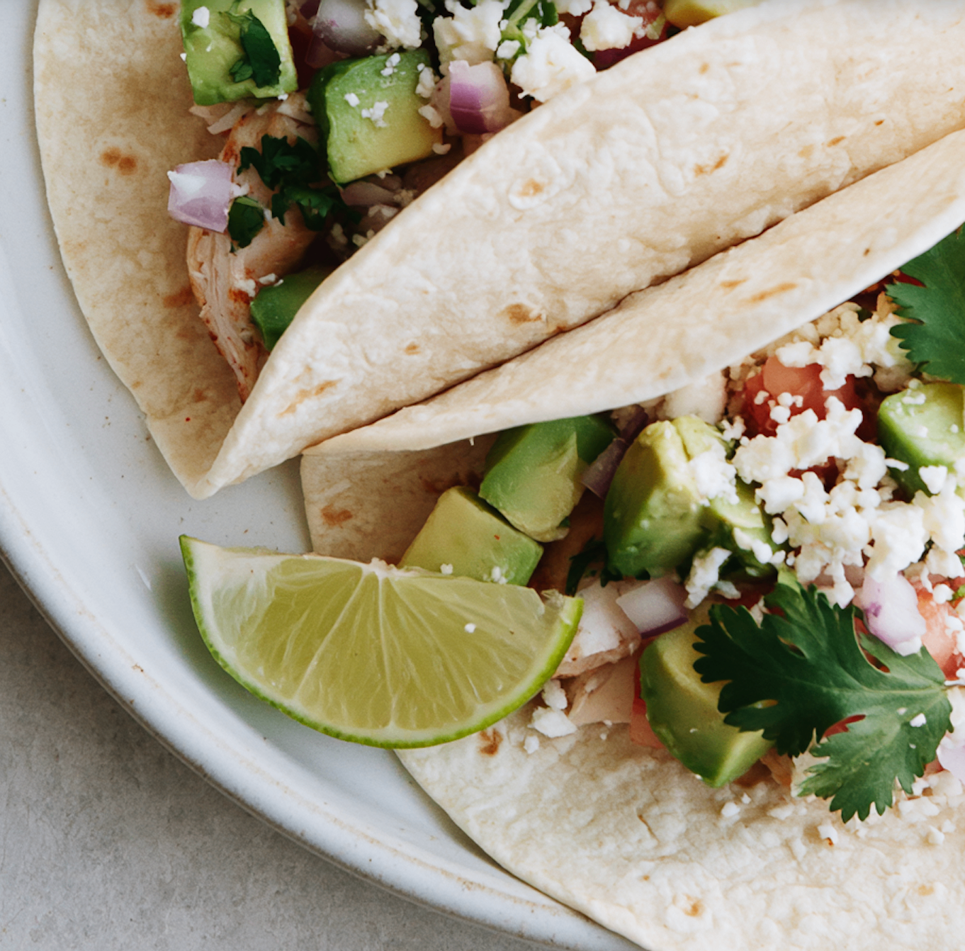 Fresh chicken tacos with avocado, feta, cilantro and lime — a lecker meal